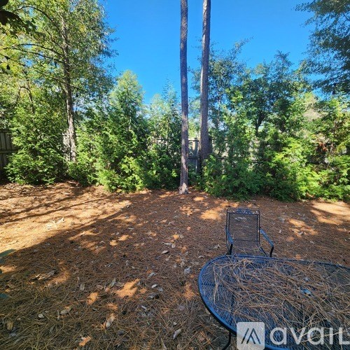 A metal table surrounded by trees in a forest.