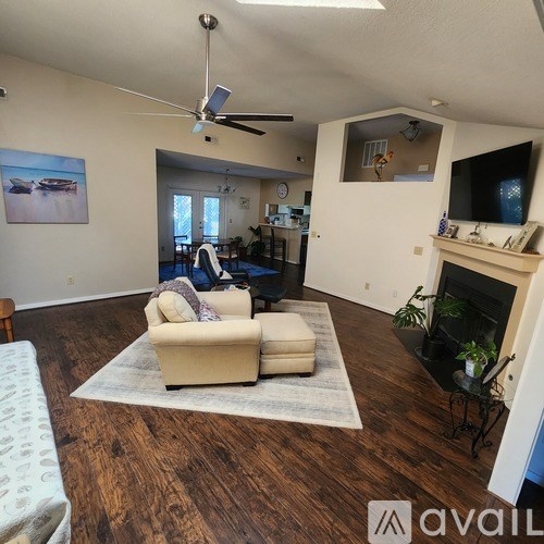 A living room with a couch, a chair, a fireplace, and a television.
