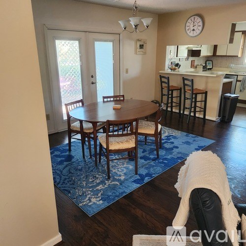 A dining room with a round table and chairs.