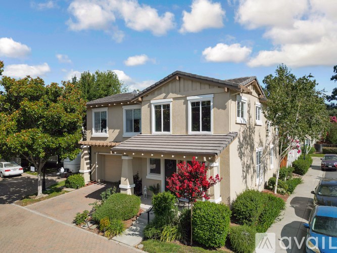 A house with a red flower in front.
