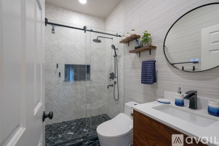 A bathroom with a white toilet, a sink, and a shower with a glass door.