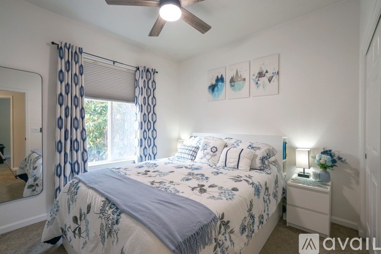 A bedroom with a bed, nightstand, and a ceiling fan.