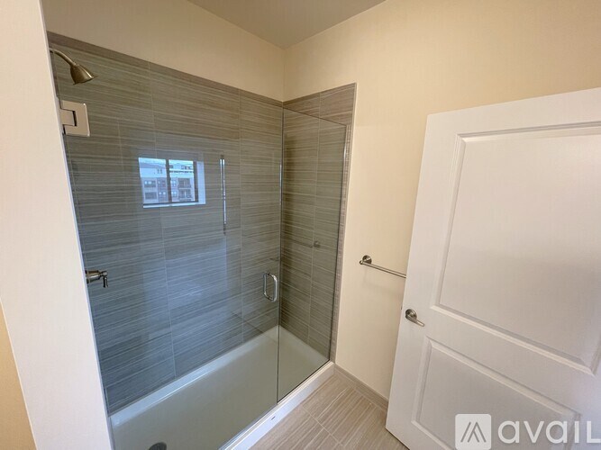 A bathroom with a glass shower door and a white door.