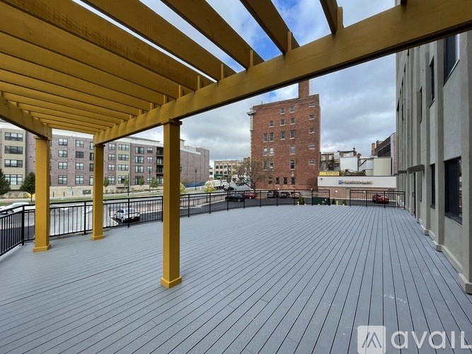 A wooden deck with a pergola and a view of a cityscape.