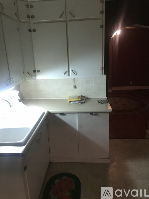 A kitchen with white cabinets and a window.