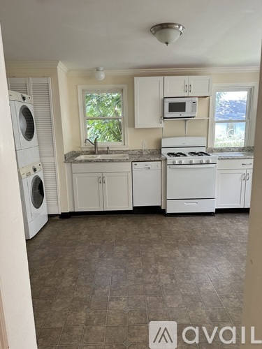 A kitchen with white appliances and cabinets.