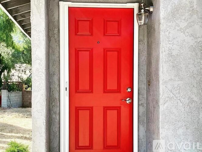 A red door is closed and has a silver handle.