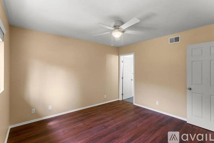 A room with a ceiling fan and two doors.