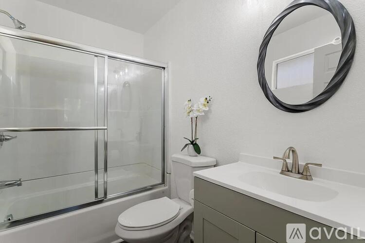 A bathroom with a toilet, sink, and mirror.