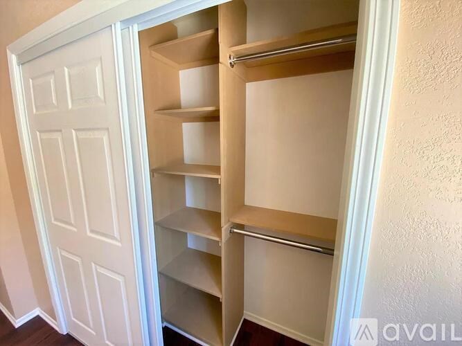A white door with a shelving unit inside.