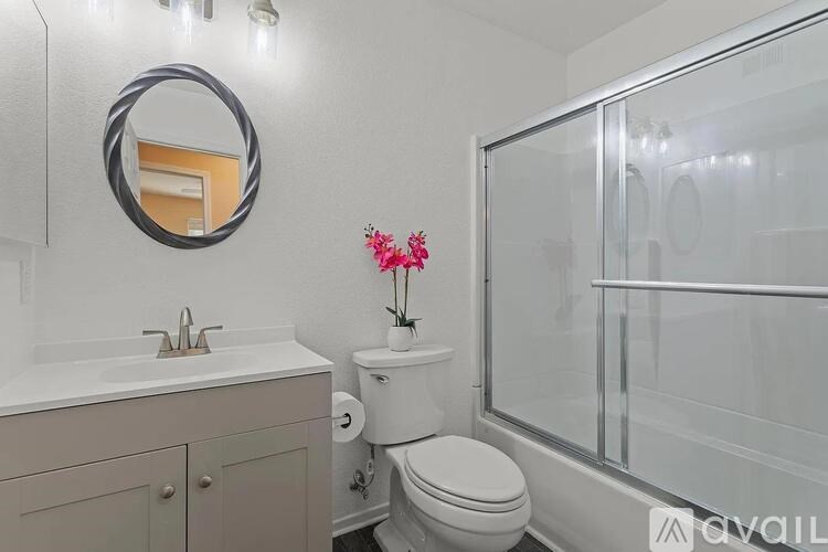 A bathroom with a toilet, sink, and mirror.