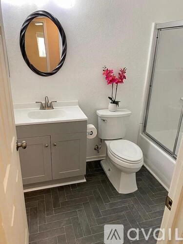 A bathroom with a toilet, sink, and mirror.