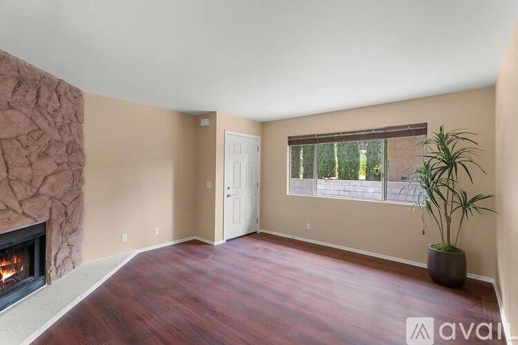 A room with a fireplace and wooden flooring.