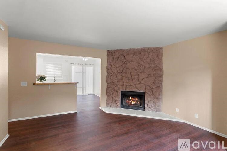A living room with a fireplace and a plant on the windowsill.
