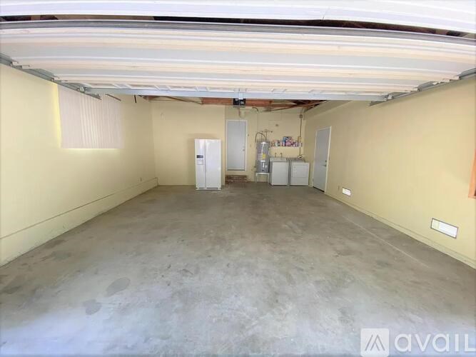 A spacious empty room with a concrete floor and white walls.