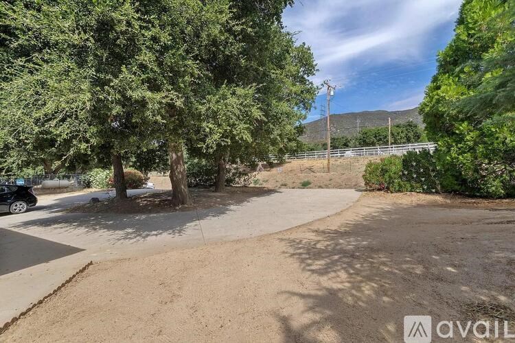 A parking lot with a car parked and trees around.