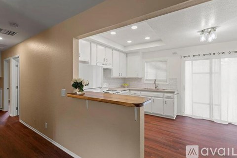 A kitchen with white cabinets and a wooden countertop.