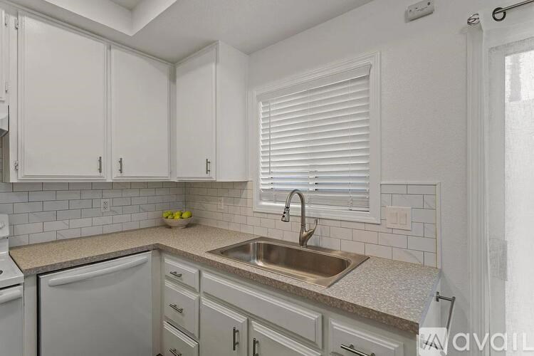 A kitchen with white cabinets and a sink.