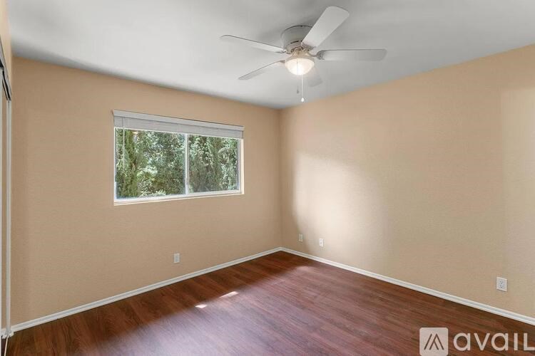 A room with a ceiling fan and a window.