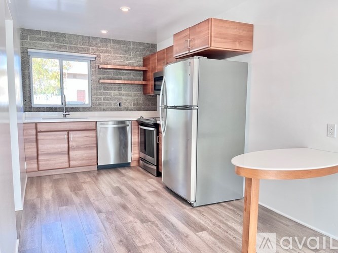 A kitchen with a refrigerator, oven, and microwave.
