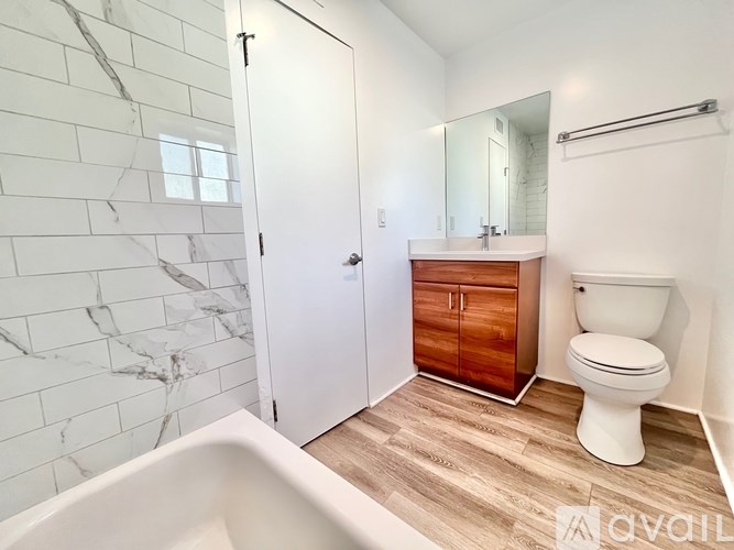 A white toilet sits next to a sink in a bathroom.