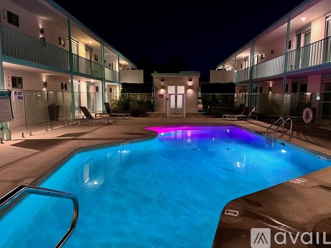 A swimming pool with a lit up purple light in the middle.
