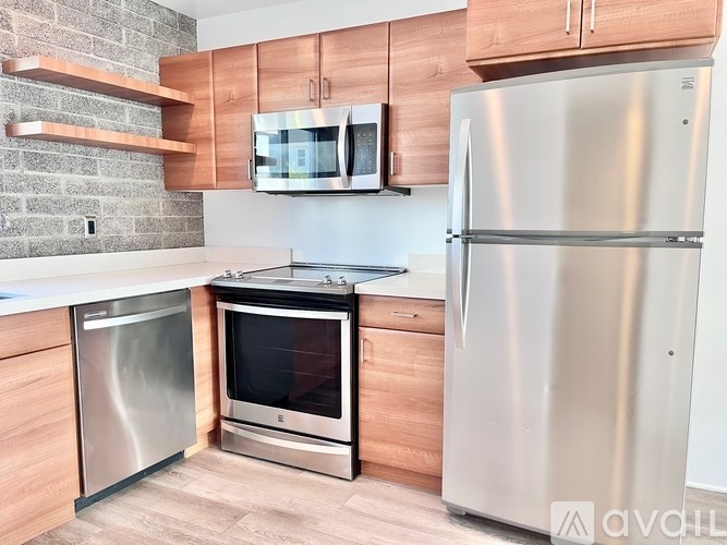 A kitchen with a refrigerator, oven, and microwave.