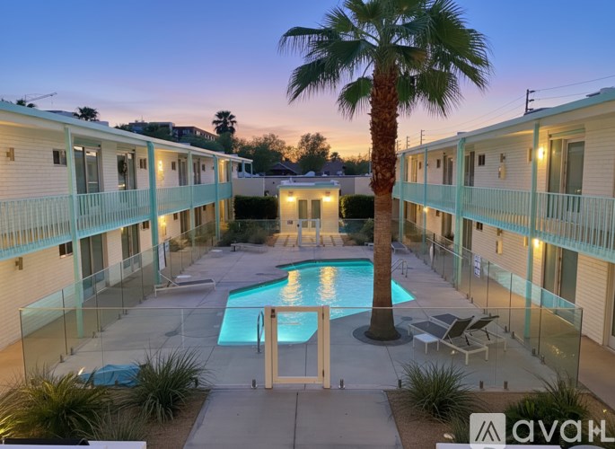 A palm tree stands in the middle of a pool surrounded by apartment buildings.