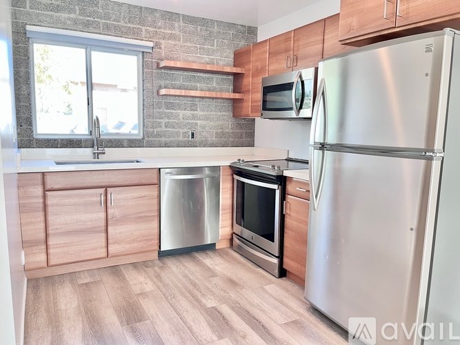 A kitchen with a refrigerator, microwave, and oven.