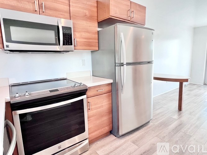 A kitchen with a stainless steel refrigerator, microwave, and oven.