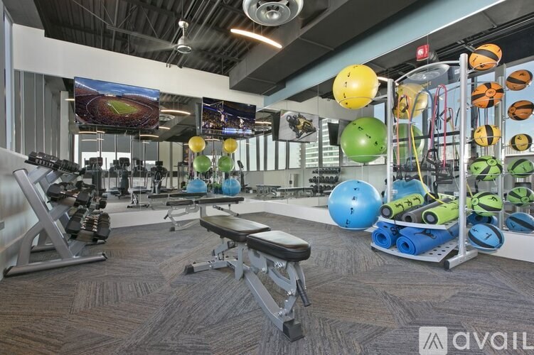 A gym with a variety of equipment including weights and exercise balls.