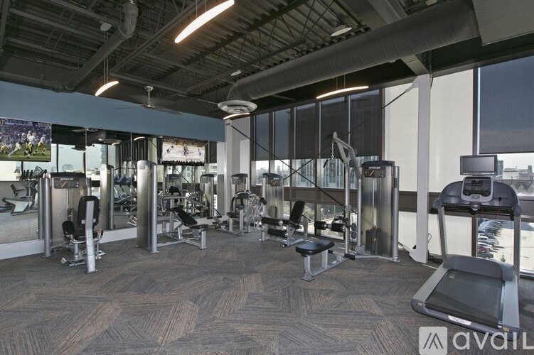 A gym with a variety of equipment including treadmills, weights, and exercise machines.