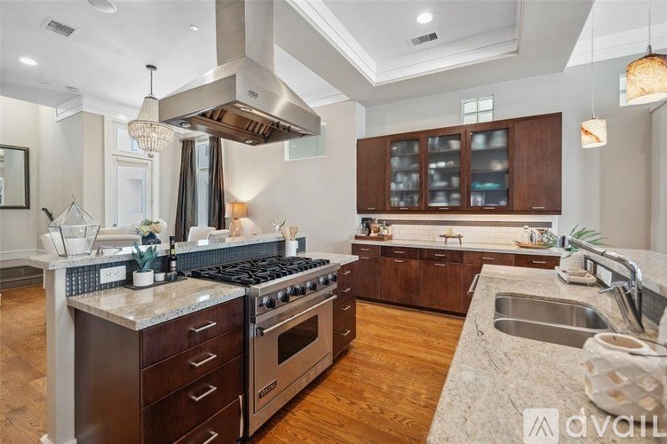 A modern kitchen with dark wood cabinets and a stainless steel range hood.