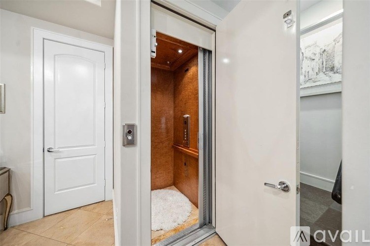 A white door is open to a room with a brown wall.