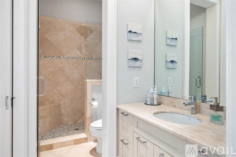 A bathroom with a walk-in shower and double sink vanity.