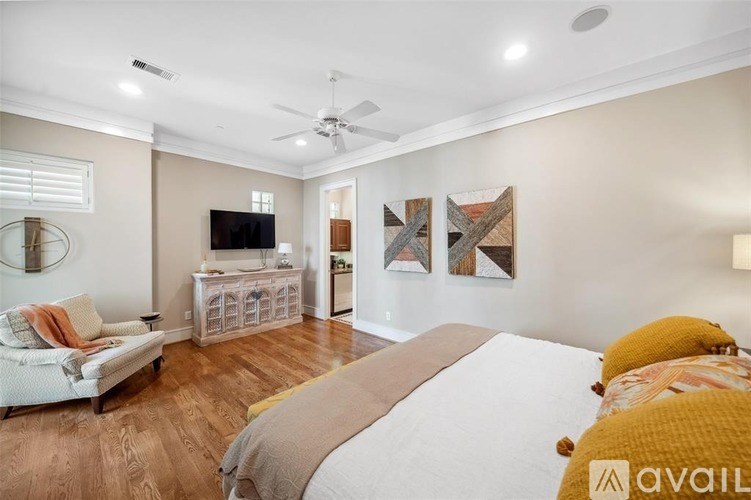 A bedroom with a bed, a couch, a TV, and a wooden cabinet.