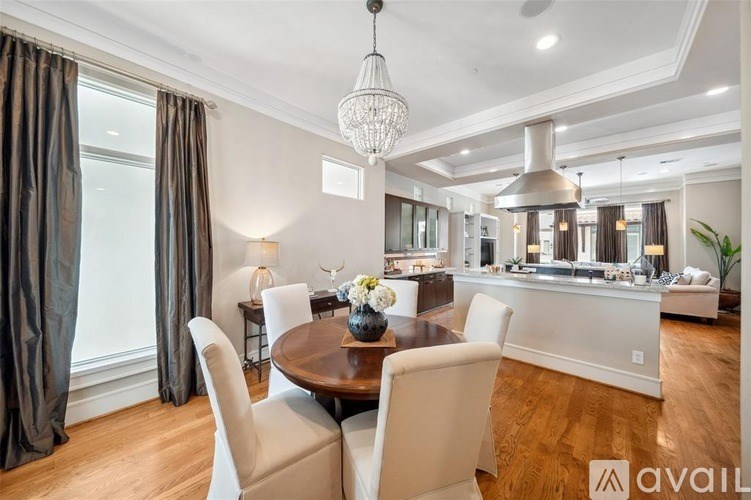 A dining room with a round table and chairs.