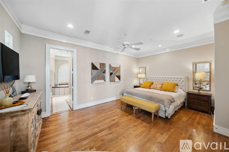 A bedroom with a bed, a dresser, and a ceiling fan.
