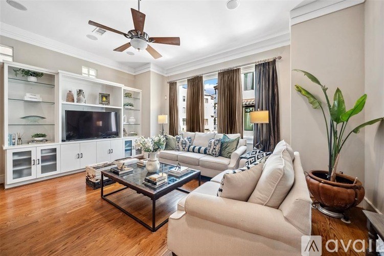 A living room with a white couch, a coffee table, and a ceiling fan.