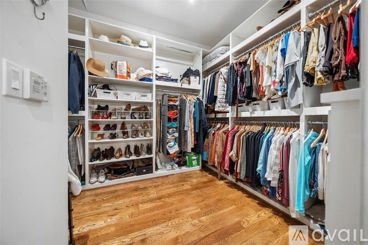 A spacious walk-in closet with neatly organized clothes and shoes.