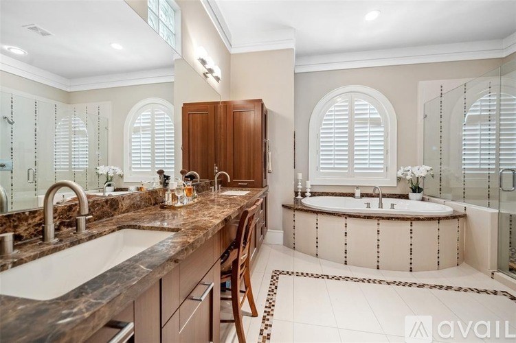 A bathroom with a marble countertop and a round bathtub.