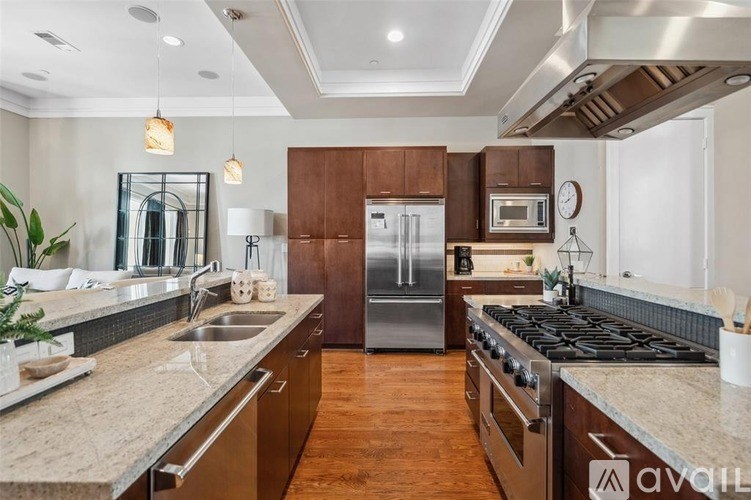 A modern kitchen with wooden cabinets and a stainless steel refrigerator.