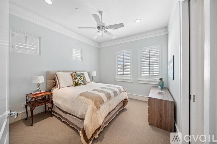 A bedroom with a large bed and a ceiling fan.