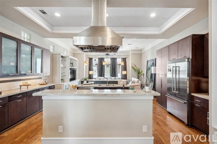 A modern kitchen with a large island and stainless steel appliances.