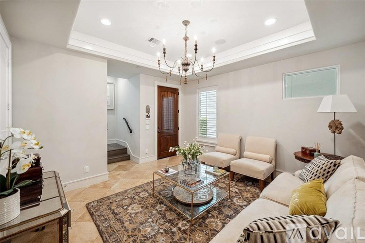 A living room with a chandelier, sofas, and a coffee table.