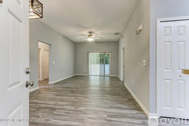 A spacious room with wooden flooring and white walls.