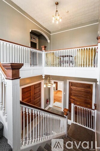 A staircase with a white railing and a brown handrail.