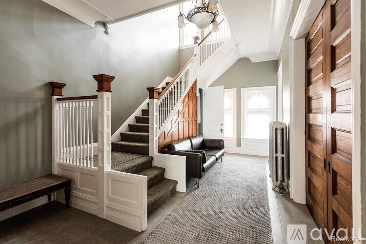 A staircase with a wooden banister and a light fixture above it.