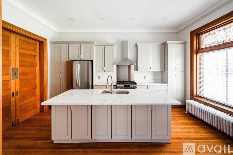 A kitchen with a white countertop and wooden floors.
