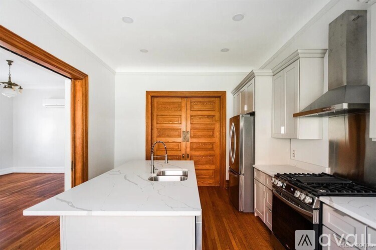 A kitchen with a white counter top and a wooden door.